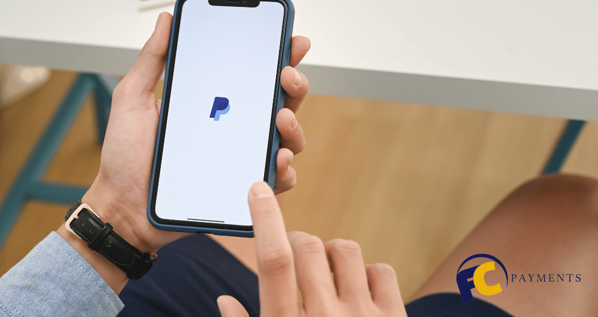 A person using a laptop to access their PayPal account and view payment processing options