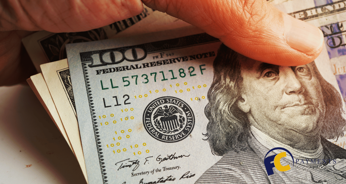 A man holding a credit card with the Bank of America logo on it and a document in the background