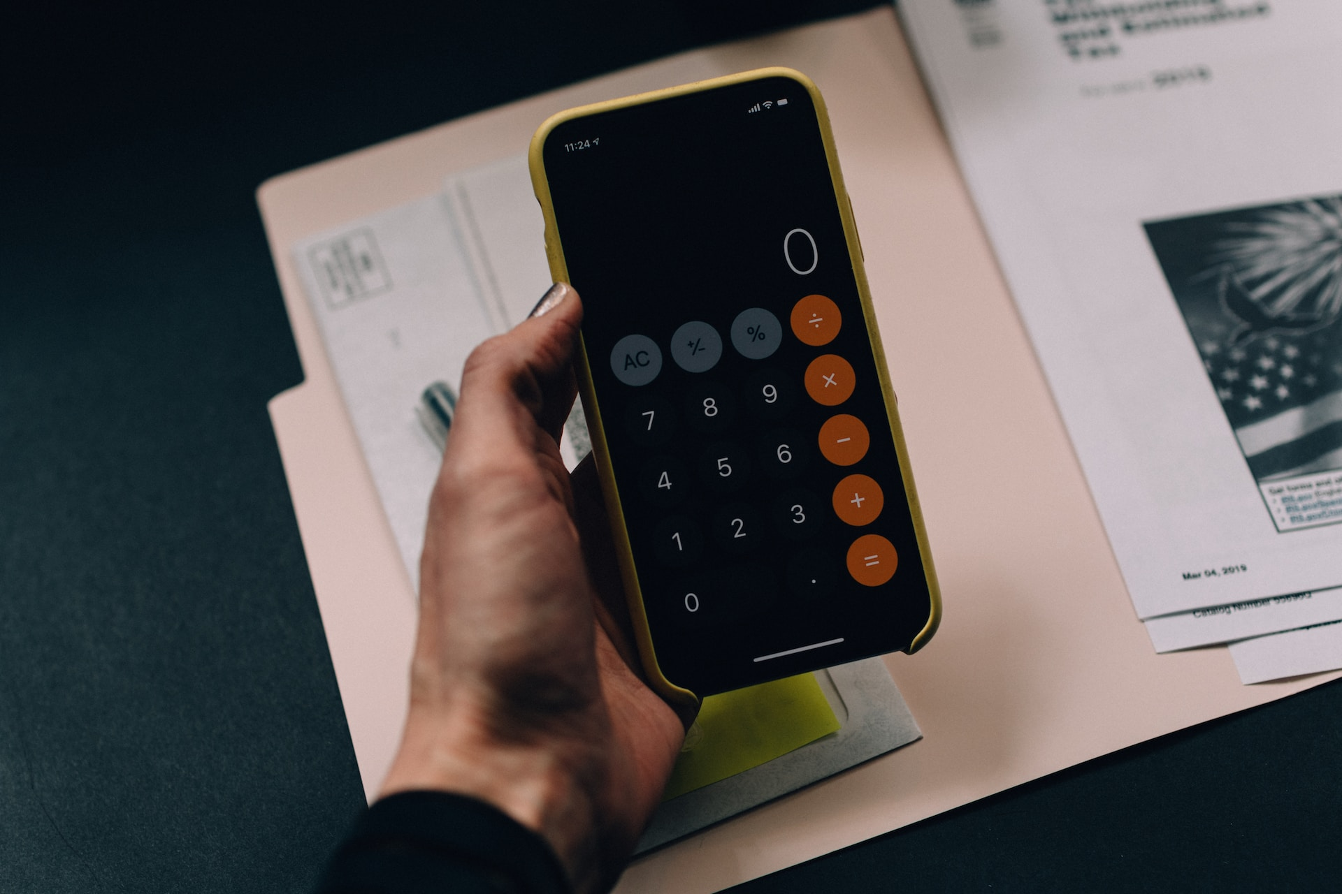 A person using a calculator to estimate PayPal costs