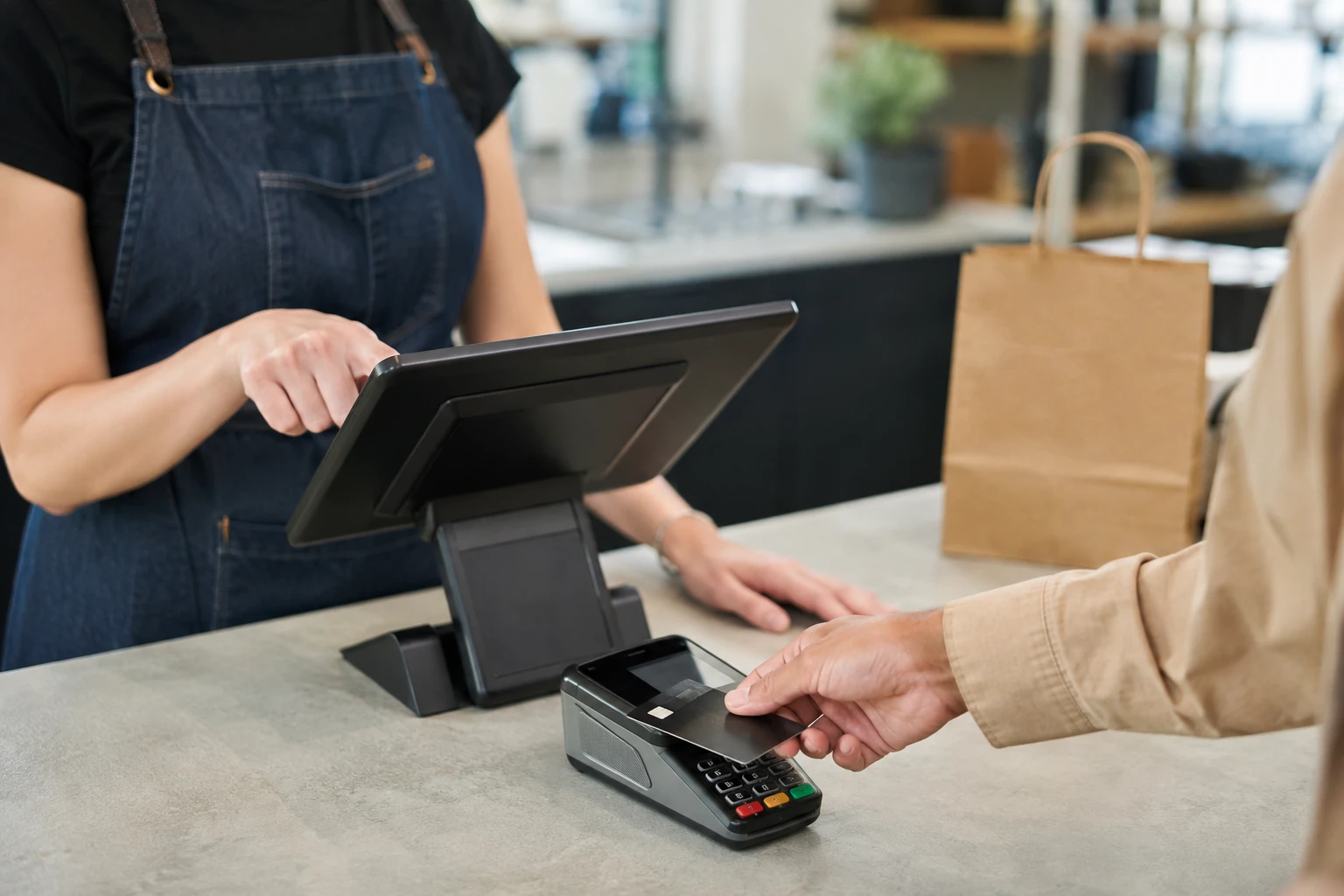 Customer completing a credit card transaction at a merchant point-of-sale register.